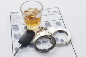 HandcuffsWhiskeyAndKeysOnTopOfFingerPrints