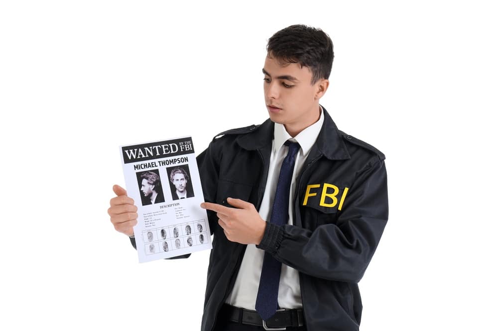 MaleFbiAgentWithWantedPosterOnWhiteBackground