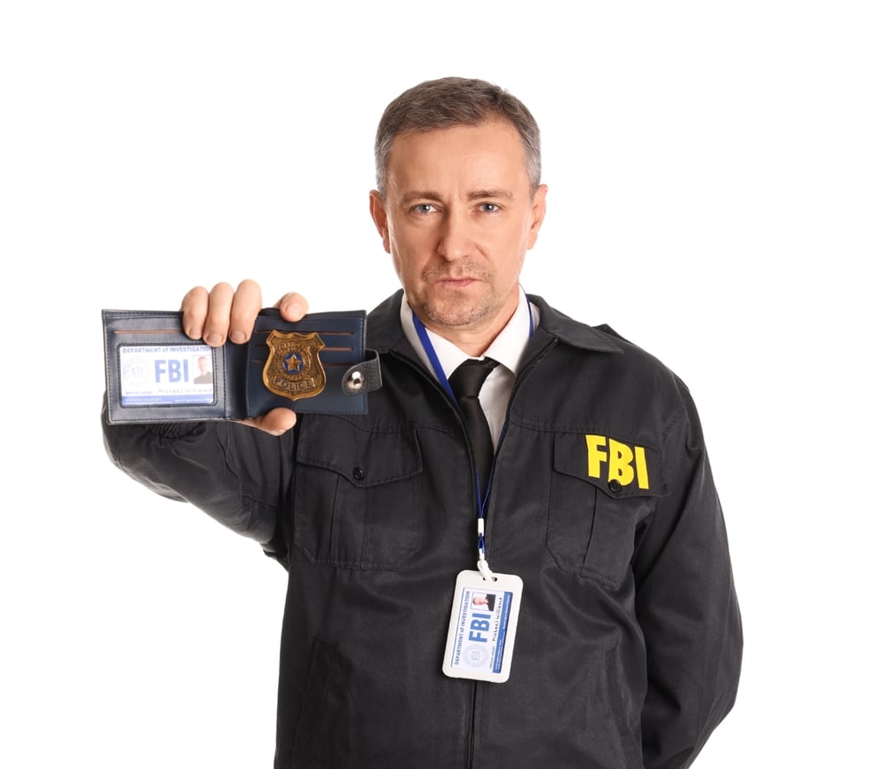 MatureFbiAgentShowingDocumentOnWhiteBackground