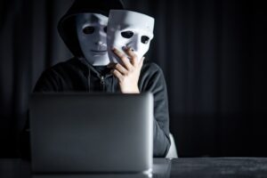 MysteryMaleHoodieHackerWearingMaskHoldingWhiteMaskSitting