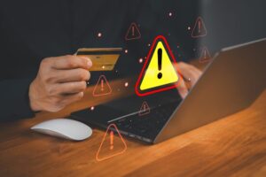 CustomerHandHoldingACreditCardWhileUsingALaptop