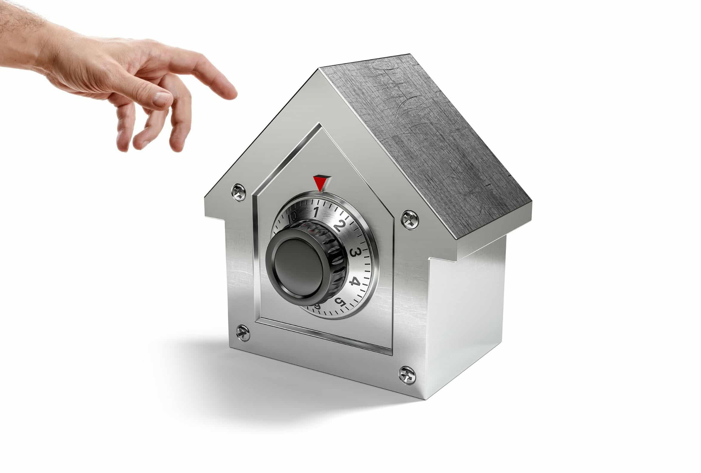 Hand reaching toward a metal safe with a circular combination dial.